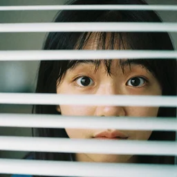 cropped zoom close-up of unexpected eye contact with a neighbor through their blinds, telephoto, kodak portra 400 film