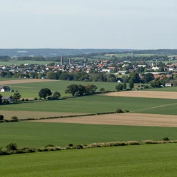Landscape photograph of countryside with a town in the distance. Detailed, UHD, realistic