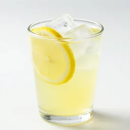 Photograph of a brightly lit glass cup, full of lemonade and lemon slice ice cubes