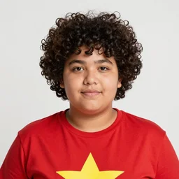 a chubby boy with curly black hair and a red shirt with a yellow star on it