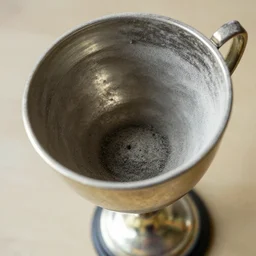 a trophy cup, filled to the rim with dust and ash on the inside, 8 k hdr picture, top - down angled view
