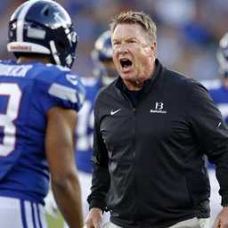 Coach Belichick with glowing red eyes yelling at a football player
