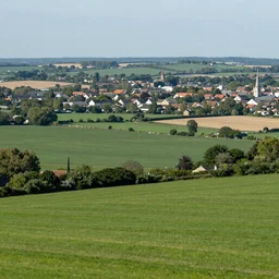 Landscape photograph of countryside with a town in the distance. Detailed, realistic.