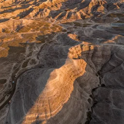 aerial overhead close up drone shot of badlands plains ground in golden hour lighting