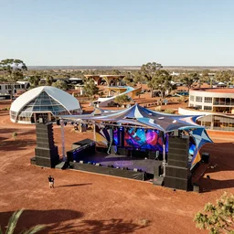 psytrance party in the australian outback, with dancefloor and speaker stack, with beautiful architecturally designed living structures, concept art, urban planning, XF IQ4, 150MP, 50mm, F1.4, ISO 200, 1/160s, natural light