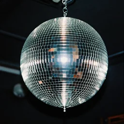 a disco ball shaped like a skull full of long spikes, reflecting light in a nightclub, grainy film photograph
