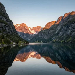 a Norwegian fjord surrounded by mountains with the sun rising, trees on the mountain sides, completely still mirror water reflecting the surroundings