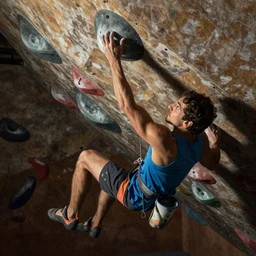 a photo of a brazilian man bouldering indoors