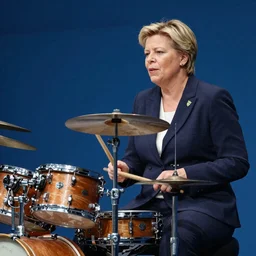 A photo of The Prime Minister of Sweden, Magdalena Andersson, playing a drums on stage. natural colors, character photography, Exquisite detail, post-processing, masterpiece, photorealistic