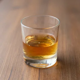 a realistic photograph of a glass of whiskey on a wooden table