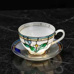 Stained glass teacup by Louis comfort Tiffany, translucent, overhead lighting on black marble tabletop