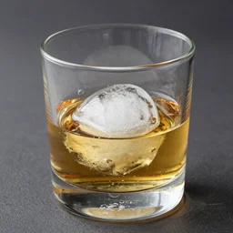 a glass of whiskey with a ball of ice