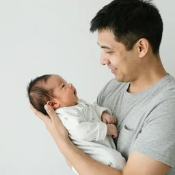 photo of a young dad holding his newborn son