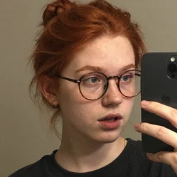 ginger nerd with a honest reaction, taking a selfie, grainy quality, low quality, low resolution, realistic, hyperrealistic, very realistic, hd quality, intricate details, very detailed, grainy, taken on an iphone, awkward angle, awkward lighting