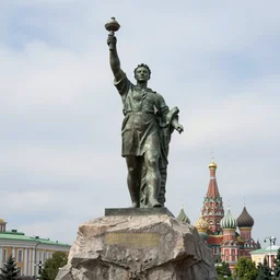 the statue of zelensky stands atop a large rock with moscow below