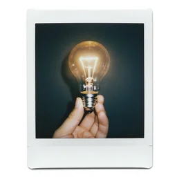 hand holding a gleaming lightbulb, polaroid photo, surreal,
