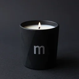 a modern black geometric wax candle, high resolution photo, on a dark background, with the letter m somewhere in the image