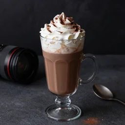 food photography of hot chocolate drink in tall glass with cream on top and cocoa powder, canon macro lens, moody lighting